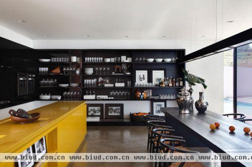 开放式的厨房和餐厅成为一个空间，黄色的岛柜格外醒目，汉斯·瓦格纳的 wishbone 餐椅以及那些精致的摆件增添了空间的艺术感。