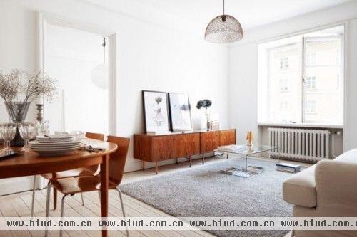 北欧居室一般崇尚简约，白色为主，白色的墙体和褐色餐桌是不变的准则。地毯带有装饰性画面，特色的家具，使得房屋不仅有简约美还有时尚感，有着北欧的一贯生活态度。
