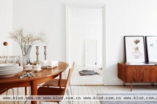 北欧居室一般崇尚简约，白色为主，白色的墙体和褐色餐桌是不变的准则。地毯带有装饰性画面，特色的家具，使得房屋不仅有简约美还有时尚感，有着北欧的一贯生活态度。