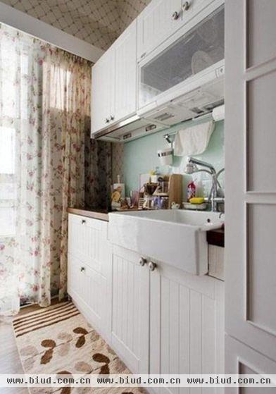 直线型厨房仅占很小的空间，开放式的设计让厨房与客厅融为一体，选用白色的橱柜和淡绿色的墙砖可以让视觉更加清淡素雅，减少空间的拥挤感。