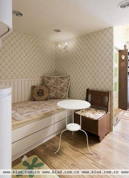 进门处便是小小的客厅，设计了一个卧榻也是一个卡座，具有收纳的功能。