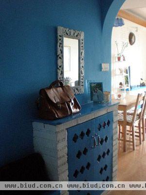 这是一套地中海风情的乡村小屋，蓝色作为主色调，白色作为装饰，给人一种清新自然的感觉。玄关处的砖砌鞋柜，客厅的砖砌电视柜，蓝色木质镂孔门板，精致纯朴。地中海风格小吊灯，拱形门，花边镜子，深蓝布艺沙发，木质摇椅，把这个小家装饰得精致温馨，到处都透着海洋的气息。