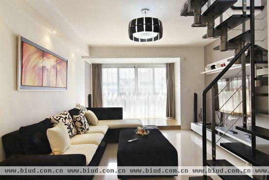 客厅的沙发是运用黑白两色的布艺沙发和茶几。这样尽显时尚的感觉。采用落地玻璃，使客厅的采光效果不错。