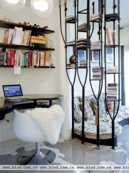这里是书房空间，书房和客厅通过铁艺书桌作为空间分割界限。书房的现代塑料沙发椅