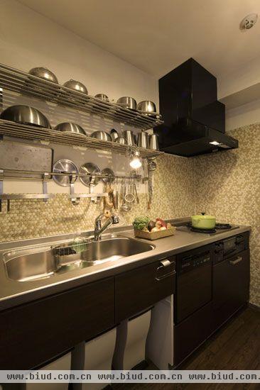 厨房区域，整齐大方。深木色的整体橱柜，简洁大方，上面一层金属色彩的出台，宽敞的洗漱池，不仅便于打扫，而且格外整齐。