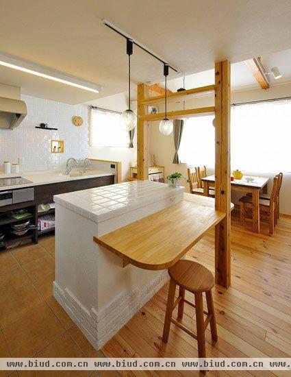 现代化的厨房装饰，多半是以开放的样式展现的，开放式的厨房，没有棱棱角角的束缚，使空间看起来更加宽广。厨房的外围，白色的马赛克和砖块拼凑而成的墙壁，外侧一个木板可以用作小餐桌，再搭配一个同样木质的小圆凳，仿佛速食店中的小餐桌，淡雅简洁。砖块拼凑的墙面，斑驳的印记，带来了一种厚重的历史感。