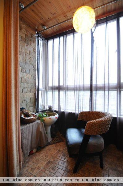 与餐厅相连的阳台被打造成一个休闲空间，肌理感很强的石材和桑拿板，配上鱼缸和球形吊灯，让这个空间充满了自然的气息