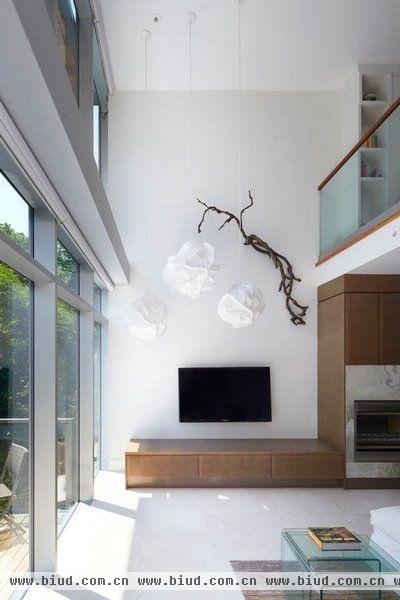 设计师使用了落地玻璃，使得可以在客厅中看到室外的绿色景观，另一方面将客厅二层挑高，在视觉上扩展了空间。