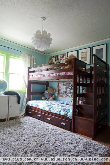 走廊进来首先来到的是双胞胎姐妹们的房间，居室里面三人两房，为姐妹两人准备的这种双层床铺毫不费力地解决了空间问题。毛茸茸的地毯搭配上深木色的床架，给孩子们的房间带来了温暖的感觉。