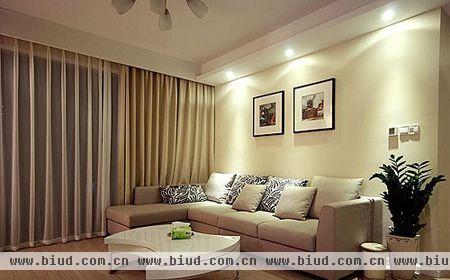 米色布艺沙发搭配同样色彩的墙面和窗帘，让客厅呈现出一派温馨祥和的氛围，加上浅色的强化木地板，让整个客厅的色调偏向温馨淡雅的感觉。