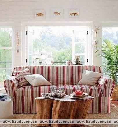  粉红条纹的布艺沙发淑女味十足，衬着典雅的白色露台，倍觉优雅。一个粗壮的树敦代替了茶几，却也并不突兀，反而多了几分原生态的自然。