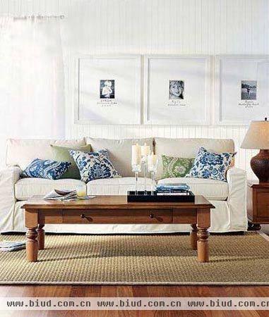 木质家具质朴沉稳，配上浅棕色地毯和白色沙发，一个适合休闲的角落就产生了。印有蓝绿花卉图案的抱枕是点睛之笔，沙发后面墙壁上的一组挂画，也是法式家居布置常用的一种手法。
