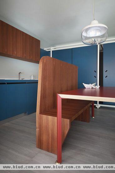 木质餐椅因其长靠背的设计起到了隔断餐厅和厨房的作用，与红木餐桌和地板搭配自然，融入整体。独特的吊灯设计让餐厅充满趣味。
