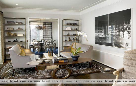 把客厅与餐厅之间的墙从中部打通，使二厅既相连又相对独立。在墙壁的两个角落对称放置储物架，增加了收纳空间的同时美化了单调的墙角。复古的地毯和造型独特的桌子，3D效果的挂画和对称摆放的沙发椅，复古风与现代感的融合让客厅充满魅力。