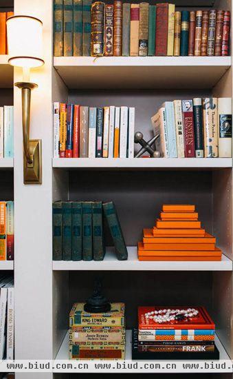 书柜间隔虽然简单，但是发挥着强大的收纳功能。从上至下，由密到疏的书籍排列让书柜的层次感更加明显，柔和的灯光把书房渲染得温馨和谐。