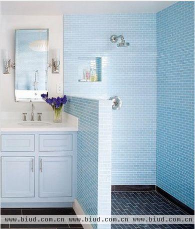 淋浴区全部采用相同尺寸的蓝色墙砖拼贴，工整中打破了白色卫浴间的单调。墙面上抠出一块四方形的小小的储物空间，将必需的沐浴用品搁置于此。