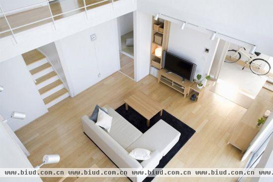 米色沙发与室内的白色墙面、木质地板相搭配，使得整体温馨舒适，更重要的是，沙发搭配显眼的黑色地毯可以作为空间的软隔断，巧妙地划分出餐厅与客厅两个区域。