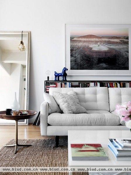 和我们经常看到的北欧风格一样，这间住宅采取了白色为主色调的装饰风格。而另一方面，住宅使用黑色、灰色、米色等中性色调的家具和装饰品，完成了空间的个性表达。简洁、富有艺术气息和线条感，仿佛工业时代的主题氛围。黑白相间的斑马地毯、厨房的蓝色椅凳和墙上的装饰画，都透露出屋主的个性和品味。