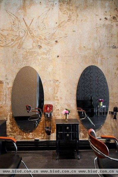 来看看加拿大的时髦沙龙是什么样的吧！这组图片由摄影师Brenda Liu拍摄，沙龙位于多伦多，由一间旧屋改造而来。黑色花纹的壁纸、水晶吊灯、枚红色的靠垫、铁艺雕花的复古装饰物，这样的搭配显得奢华而富有情调。沙龙的盥洗室，以明艳的枚红色做壁纸，充满了华丽和浪漫的气息。