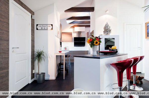厨房则充分利用了转弯角的位置，鲜花和红色的椅子为室内增添生气。