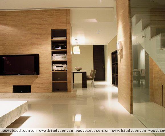  客厅部分以橡木集层材做主墙面的主要背景质材，一旁的隔柜设计，让视听器材得以收纳。