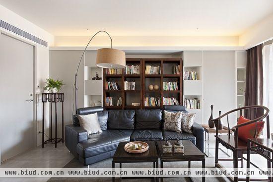 沙发背墙-焕然一新的空间却保持原本旧有的家俱，并搭配出中西合并的和谐气氛，沙发背墙则以实木书柜取代原先弧形场域，让空间方正也更加稳固。