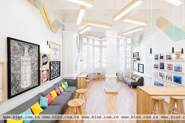 位于西班牙瓦伦西亚的2Day是一所语言培训学校，这个200平方米不到的空间里被划分为三个简洁的小教室和一个大的休息室。蓝色、粉色和黄色似乎是整个空间的主题色，小教室和休息室利用这三种颜色的搭配显得温馨活泼，淡淡的木质地板和桌椅清新自然，休息室多幅挂画增添了随意感，精致雕刻的天花板和支柱带来一丝华丽宫廷风。