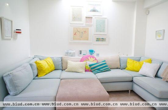 淡蓝色的棉布沙发，搭配淡粉红色的抱枕和脚架，搭配出清新小资的可爱范。鲜黄色的小抱枕更加凸显出淡蓝色的自由淡雅。墙壁上俏皮可爱的小壁画隔开墙壁白色的大色块，让客厅的设计更加清新文艺。