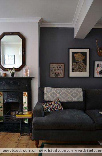 黑色的沙发搭配灰白色的沙发毯，和深灰色的墙壁构成灰色渐变三部曲，客厅的颜色变化更有动态的层次。搭配一个小小的色块补丁靠垫，让颜色冷暖平衡，达到画龙点睛的效果。