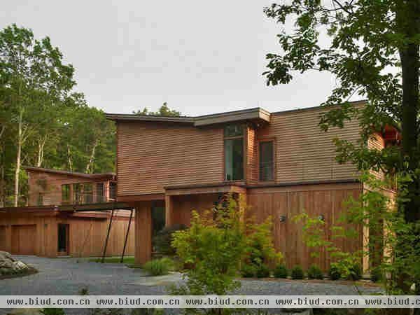 这是位于美国纽约州北部哈德逊谷的一个安静的乡村别墅。现代感的质朴风格木屋坐落在茂密的森林中，车库屋顶是让人放松的木质平台。