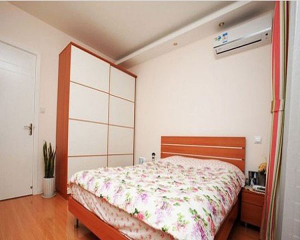卧室以选用了橙色的主色调，选用了橙色和白色相搭配的家具，再搭配上小碎花团的床品，使整个空间都散发着浓浓的温情。大大地衣柜，能满足小两口的需要。