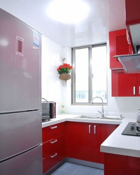  　厨房则选用了红色烤漆表面橱柜，红色柜门和白色台面的组合，使这个厨房空间散发着一种时尚的味道。 