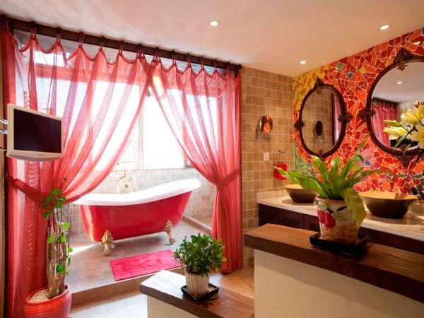 阳台扩充的浴室，视觉上显得更广阔。红色的大浴缸，金色的脚，飘逸的砂质浴帘，都一一固定，整个卫生间洋溢着热烈的红色，使人眼前一亮。 
