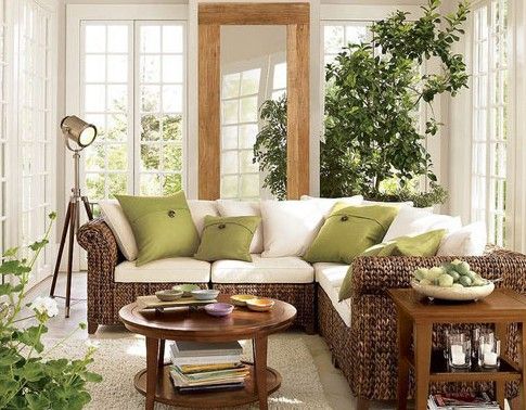 选用藤制沙发，白色的坐垫搭配绿色的靠垫，给人带来了夏日的清爽之感。同样的绿色植物，也给整个客厅空间增加了勃勃生机与活力。