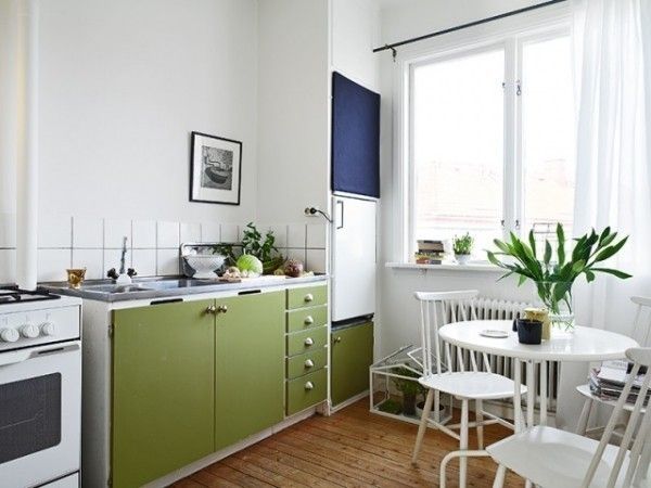 白色的圆餐桌摆放在厨房里，配上绿萝和橱柜色，有种在庭院中用餐的休闲舒适。