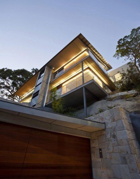 这座独特的住宅坐落在澳大利亚悉尼韦弗顿，由Richard Cole Architecture设计完成。住宅修建于一处悬崖之上，其屋顶的天窗设计则受到了洞穴的启发，客厅和卧室正上方的屋顶采用了跃层设计，一端呈弧形向上翘起，从而为下方提供更多的阳光。开放式的设计，结合木材装饰材料，呈现出质朴的风格，一块宽大的岩石将办公室与浴室分离，进一步增添了房间的原始风情。