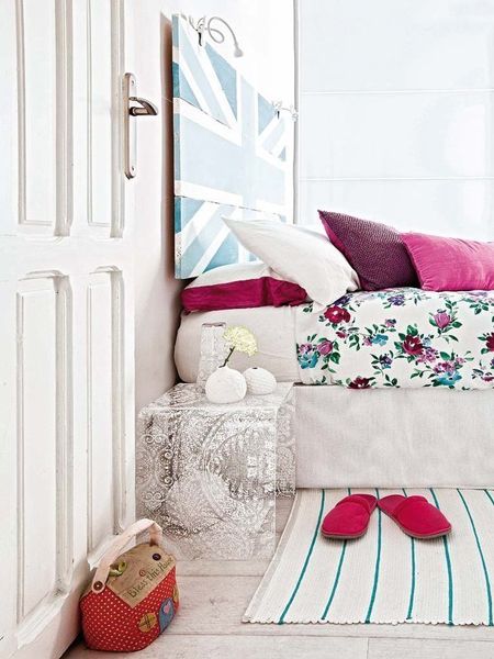 色彩清晰的大花床单以及蓝色的英伦米字旗床头背景墙，设计个性简约，卧室温馨素雅，散发出别具一格的特色。