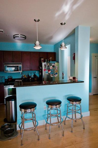 看腻了经典的白色、米色、黄色，你可有勇气接受碰撞色感受新的视觉效果？这套案例正是以蓝、绿、黄三种明显的对比色装饰88平的两居小家。客厅摆放了原木茶几和收纳柜，配上土黄色布艺沙发，复古情调即可体现。半开放式厨房设计了时尚小吧台，现代化灯具和家具在明亮的蓝色墙渲染下显示出一种清新宁静的氛围。卧室选用纯粹绿色做墙面装饰色，和原木床头柜搭配出春天活力的感觉。此外，诸多角落里散放着民族小饰品，给生活增加一点异域小情调。 