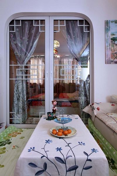 小巧的家，采用推门来阻隔客厅和卧室。中国式的花纹设计，纯白的玻璃推门让这个隔断变得与众不同。