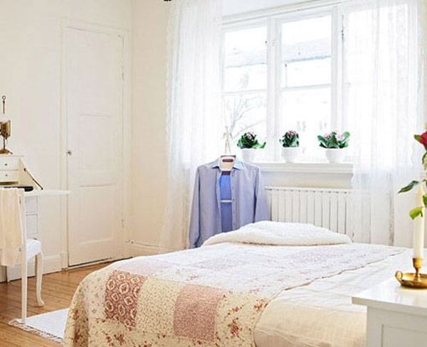 墙面上的莲花色调温和，跟披毯的色调一致，非常温柔的色调，开阔的窗户给室内提供足够的光线，依次摆放的绿植给空间带来了灵动的质感