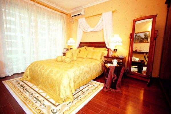 主卧金色的床盖和金色的墙纸相互搭配，既温馨又不失华丽。