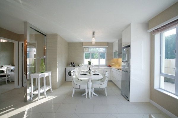 开敞的厨房与餐厅相连，餐厅纯白的家具有助于突出清贵和舒雅