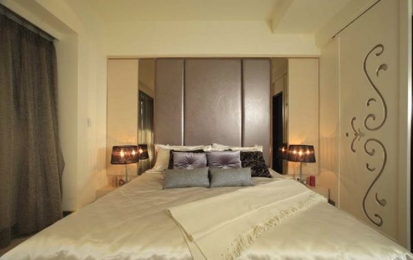 次卧房以柔性为主调，粉红、藕紫妆点空间的浪漫情感，并于床头设计对衬的活动滑门，分别隐藏床头两侧的镜面与窗户，让美感与生活机能兼具。