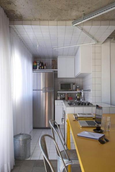 这套公寓位于圣保罗，是一个热情洋溢的 Loft 住宅，由巴西创意团队 WHYDESIGN 设计。裸露的混凝土天花和旋转楼梯，鲜艳的黄色餐桌，全白瓷砖厨房和折线安装的日光灯，APTO HARMONIA 内到处是简约粗旷的设计元素。随意复古的陈设和混搭家具，住宅的一层是厨房，餐厅，起居室和卫生间。白色半透窗帘让室内拥有充足的自然光照。