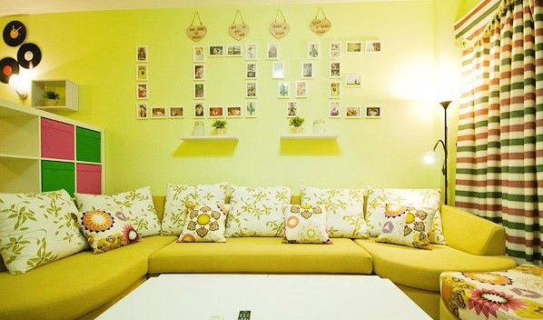 客厅的长沙发，色调与墙壁一致，一整行素雅的花卉抱枕，搭配墙上的植物搁架，营造出温馨舒适的客厅氛围。富有田园色彩的甜美系窗帘，根据采光需要选择了单层棉布的材质，红底白点配合白底红色花边，营造温馨浪漫的卧室空间。
