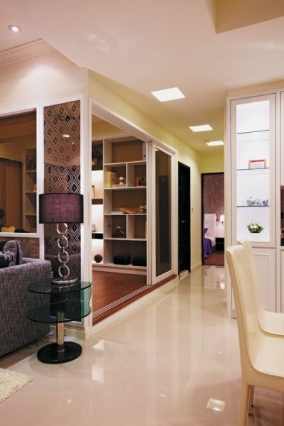 为了提升渡假式住宅的空间气度，除了在入门处以悬空的镜面高柜来安排鞋物收纳机能，并藉着低反射性的茶镜来放宽玄关的空间感。