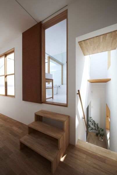 白色的混泥土墙面和木质的地板打造了这样一个简约的muji式风格家。室内功能区的划分相当明确，一楼为厨房和餐厅以及会客区，二楼是卧室和一个露天式的卫生间。一楼和二楼之间用造型独特的阶梯相连接着。