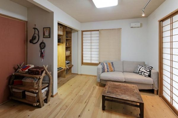 古朴的木色，将整体风格拉回到古时代的日本。卷帘式的竹制镂空窗帘，将古时期的日本风情展现的淋漓尽致。浅灰色布艺沙发，柔软舒适，搭配两个色彩艳丽的抱枕，增添了客厅的色彩感。七彩条状地毯，搭配复古木质小桌，使古朴中透出现代的气息。
