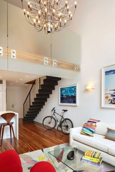 这是一个独栋住宅，占地675平方英尺（62.8平方米），位于美国纽约曼哈顿的Meatpacking District，分为上下两层，第一层有起居室、客厅、餐厅、厨房等功能区，第二层是宽大的卧室和卫浴间。室内采用的是现代简约风格，白色的墙面、木质地板，利落舒适，同时搭配多彩的家具，为空间增添了无限活力。