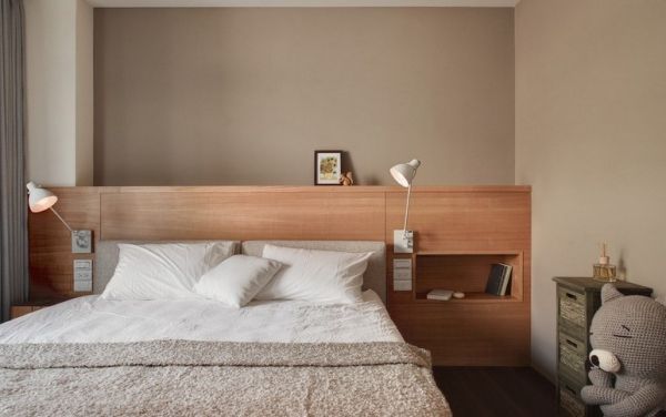 设计师演绎居家空间中的休闲感，在床头部分，以安丽格木纹柜搭配卡其带灰的壁面。